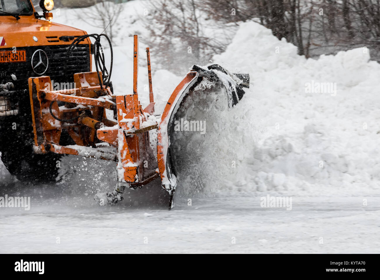 Naousa, Greece - January 13, 2018: Snow-removing machine cleans the street from the snow in the Ski Resort 3-5 pigadia during the snowfall  in norther Stock Photo