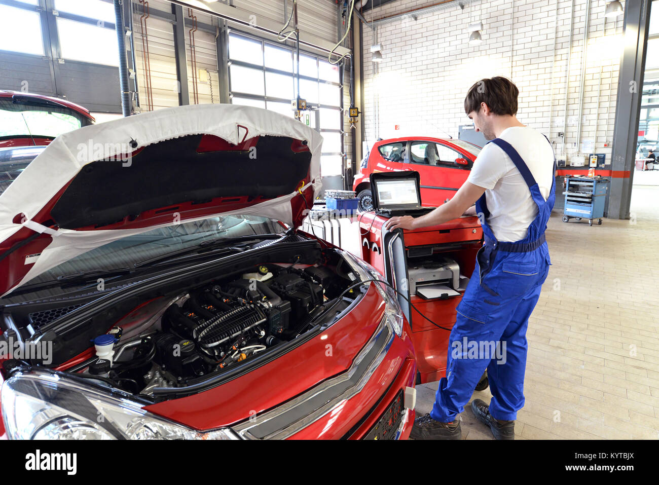 mechanic repairs motor from an automobile with the help of a diagnostic computer Stock Photo