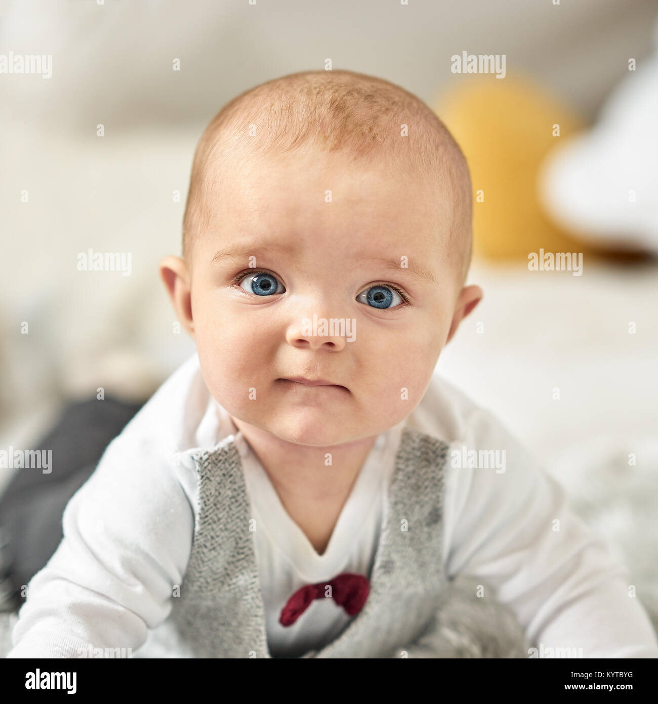 Close up portrait of baby boy with big blue eyes looking into viewer