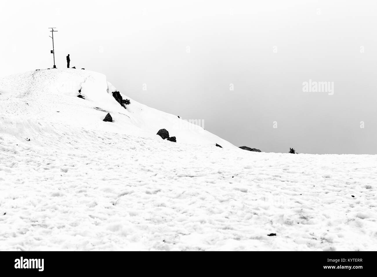 A Trekker man stands on top of triund hill top at Mcleod ganj, Dharamsala, himachal pradesh, India. Beautiful silhouette of a solo man . high contrast Stock Photo