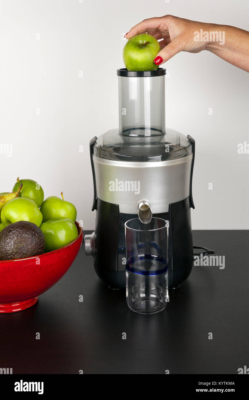 https://c8.alamy.com/comp/KYTKMA/a-womans-hand-holding-an-apple-ready-for-dropping-into-a-juicer-prior-KYTKMA.jpg