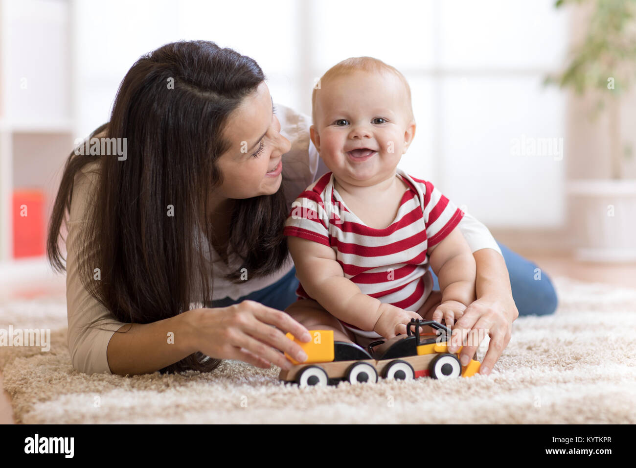 cute mother and child boy playing together with toys indoors at home Stock Photo