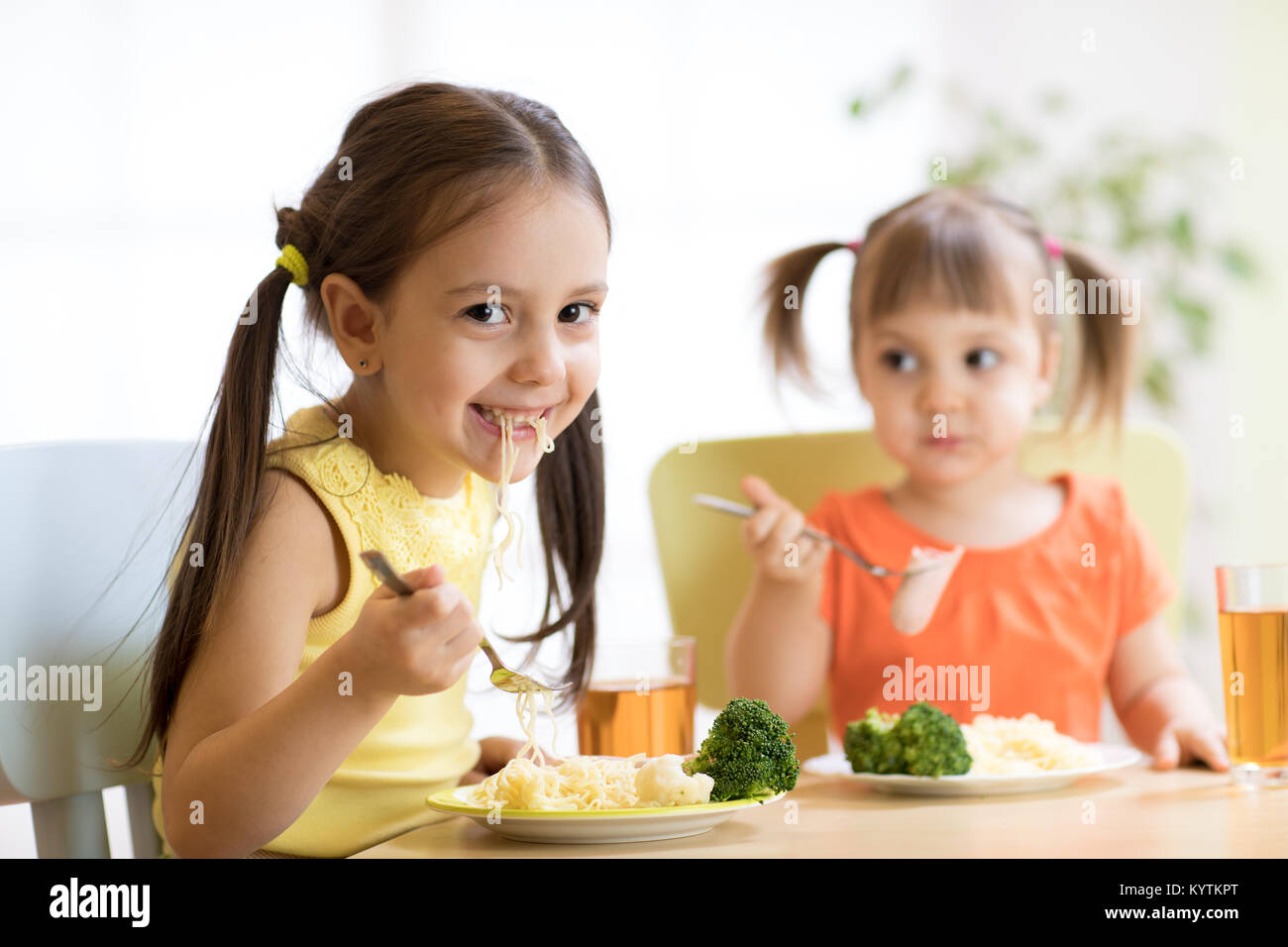 Children eating healthy food in kindergarten, nursery or at home Stock Photo