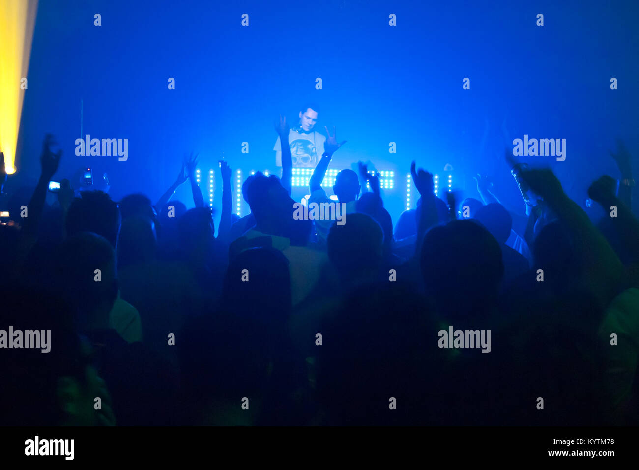 People raising their hands to the sound of techno trance music, DJ party in the club, Bangkok, Thailand Stock Photo