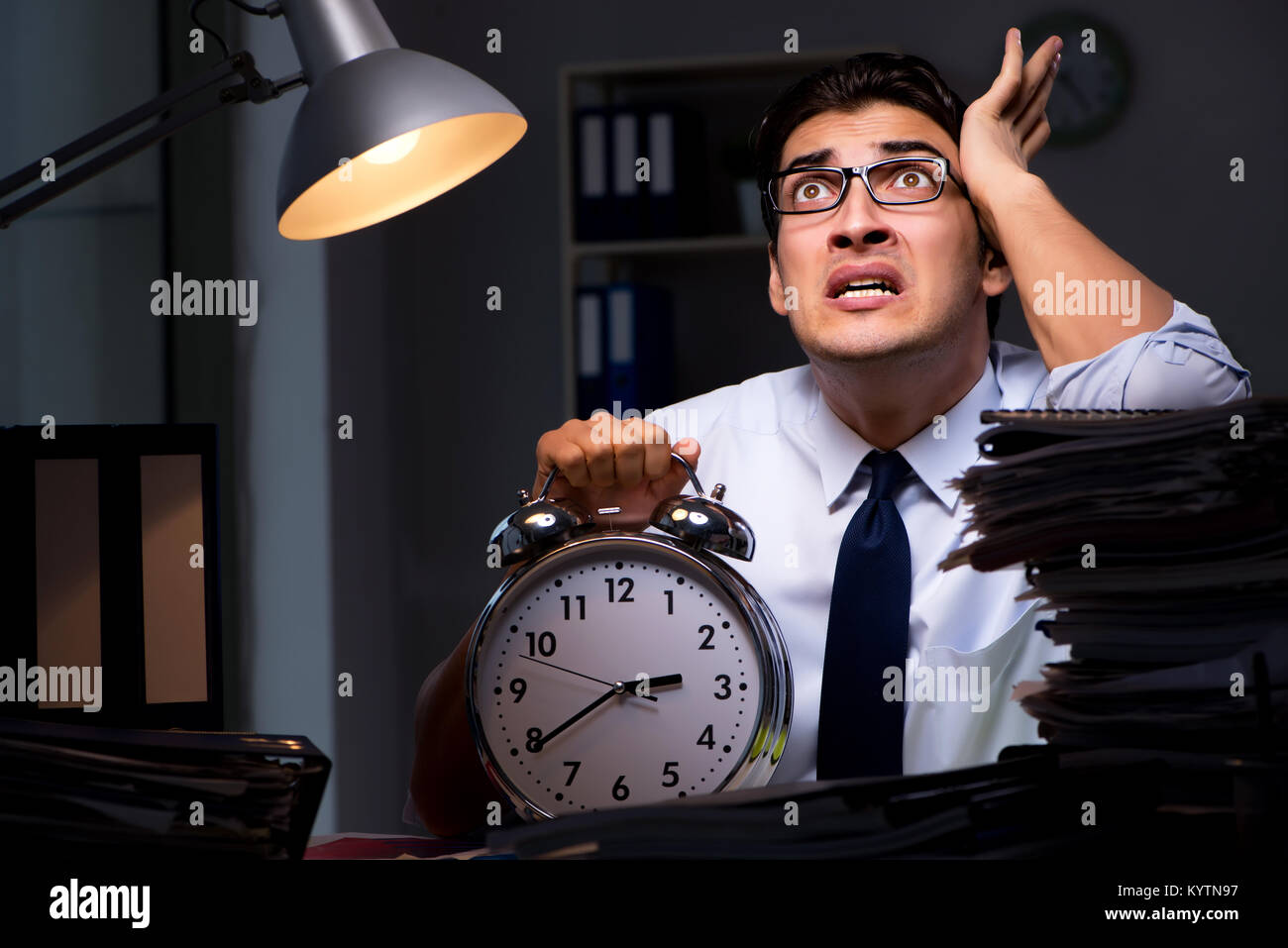 Young businessman working overtime late in office Stock Photo - Alamy
