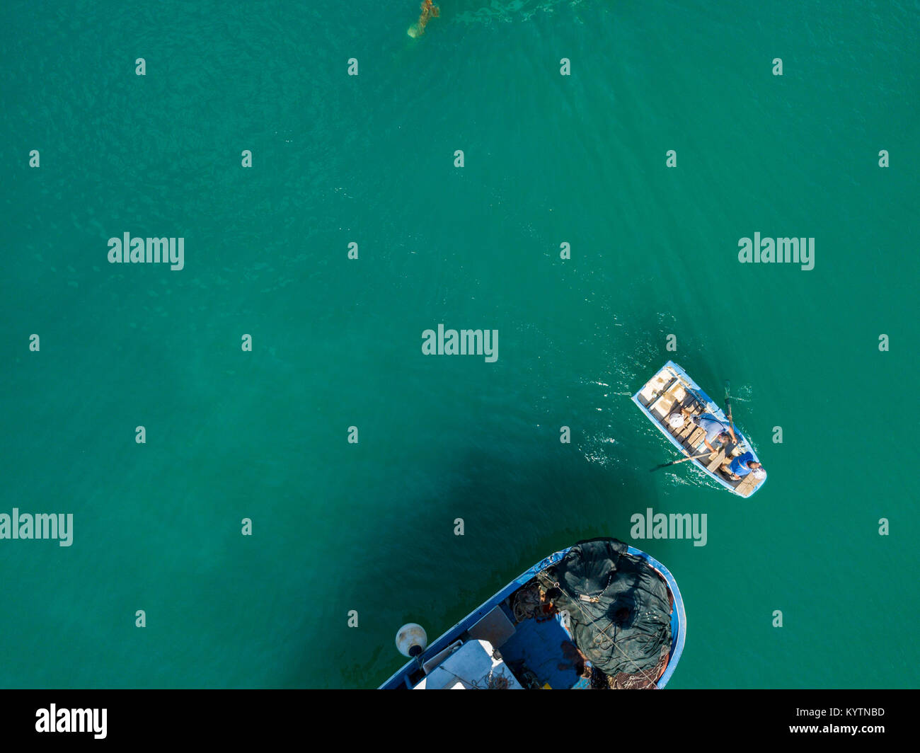 Aerial view of a Man in a boat rowing among the boats moored in a harbor. Vibo Marina. Calabria, Italy Stock Photo