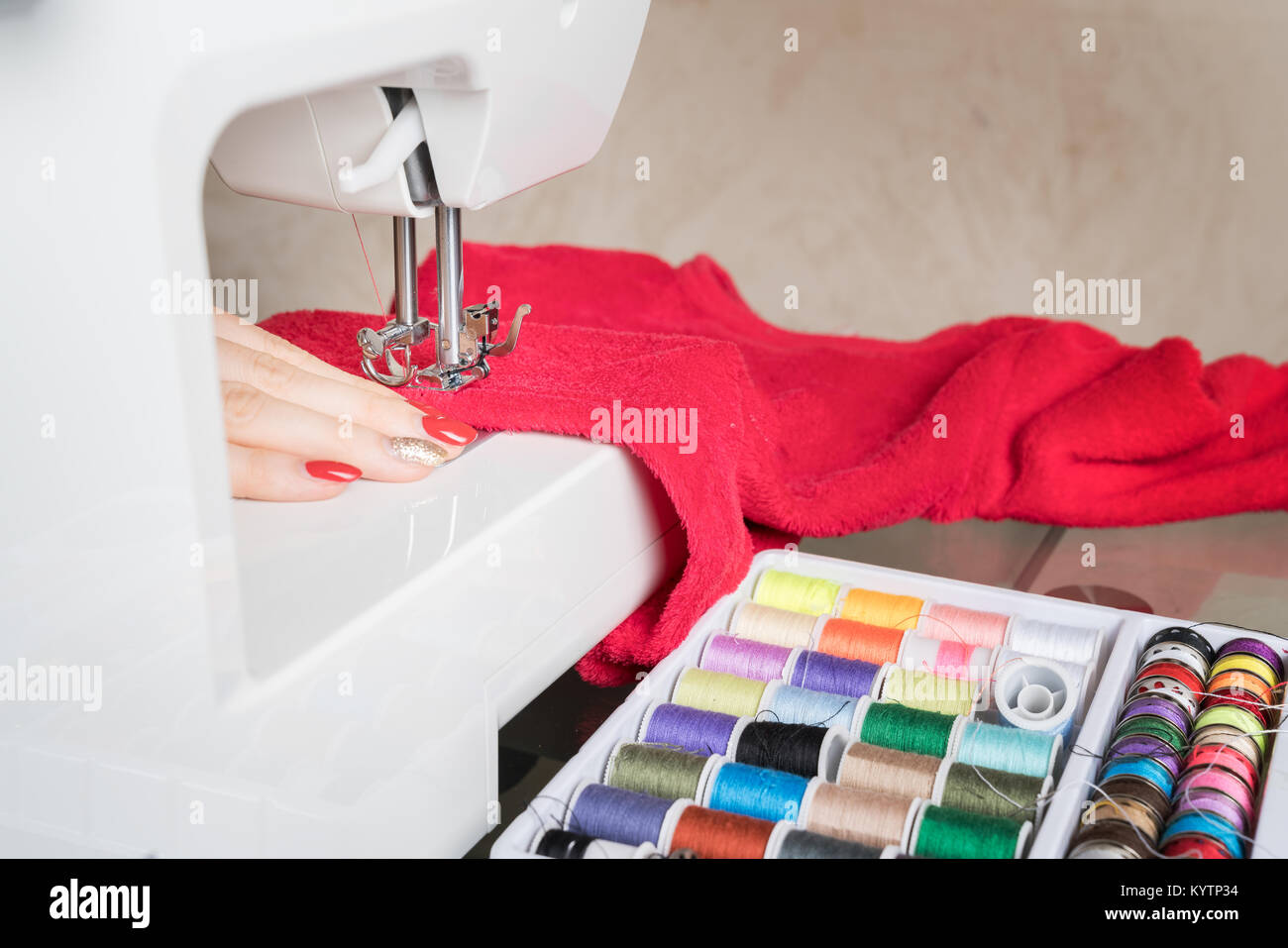 Young woman sewing fabric on sewing machine,sewing process in the phase