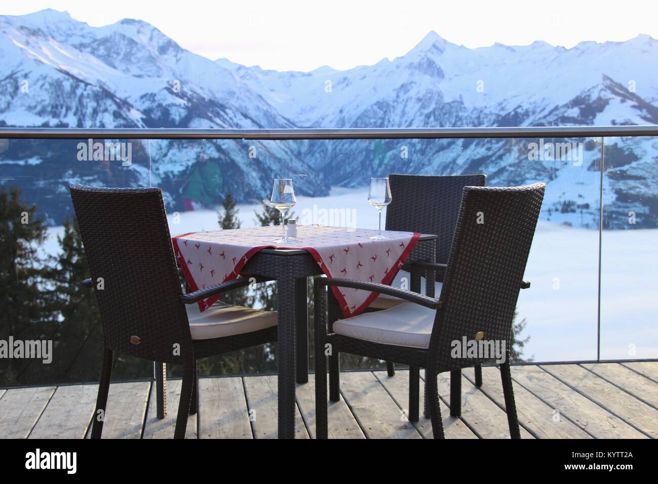 Chairs on a cafe terrace in the mountains and view of the Hohe Tauern mountain range in the region Zell am See - Kaprun, in winter. Austria, Europe. Stock Photo