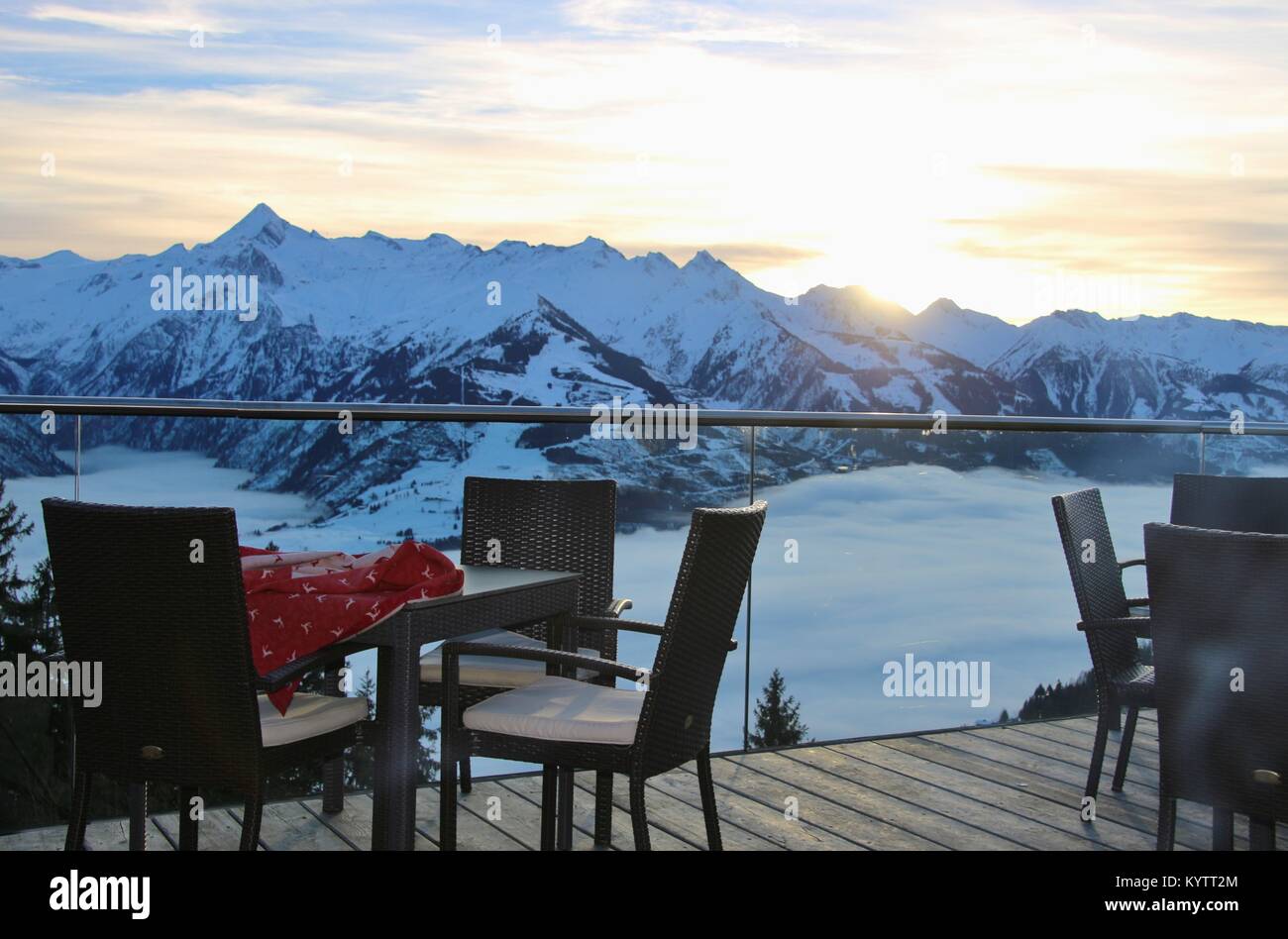 Chairs on a cafe terrace in the mountains and view of the Hohe Tauern mountain range in the region Zell am See - Kaprun, in winter. Austria, Europe. Stock Photo