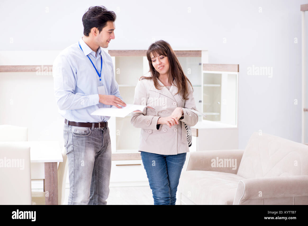 Salesman explaining to woman customer at furniture store Stock Photo ...