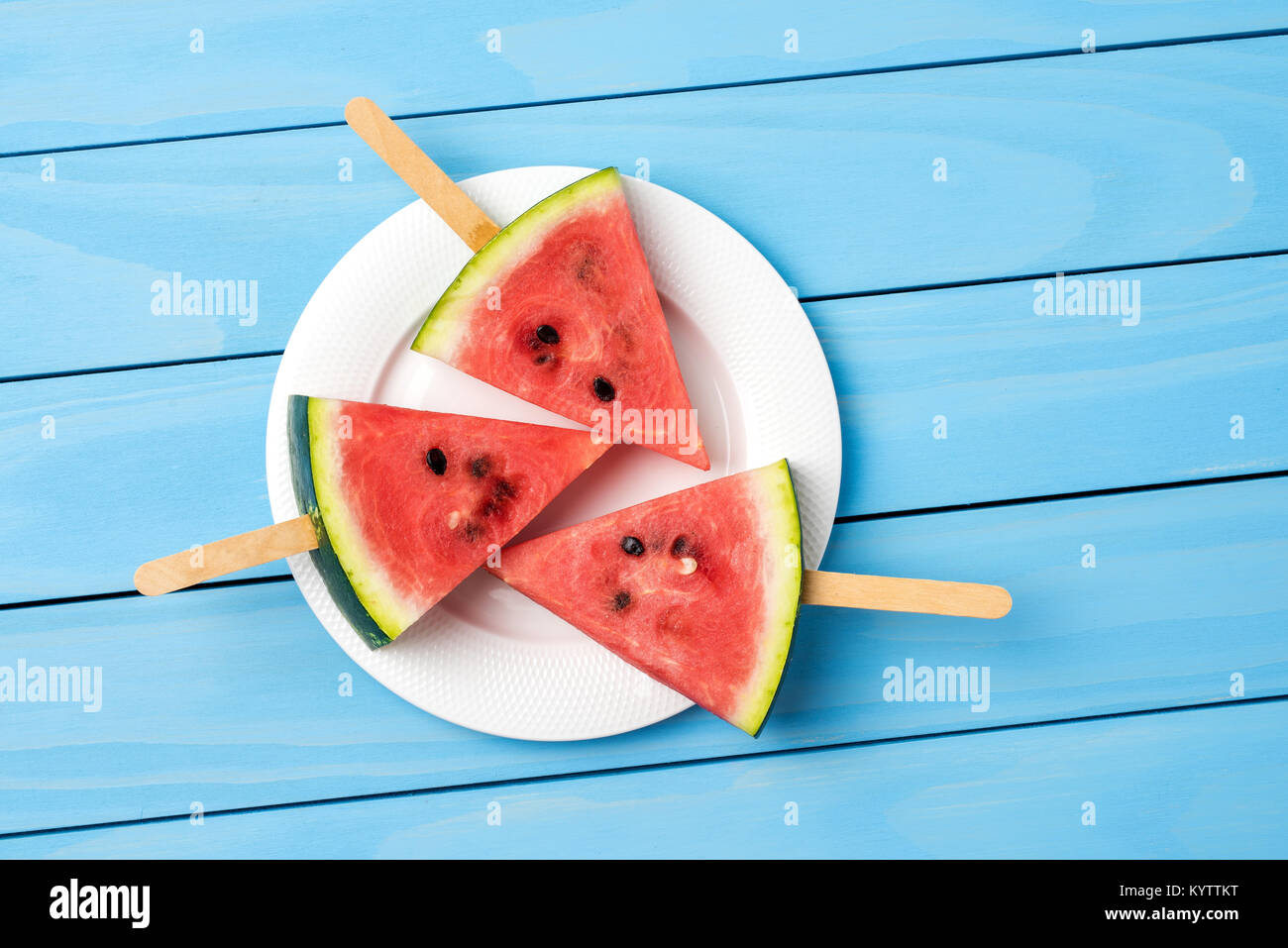 Watermelon slices on blue wooden table. Food background Stock Photo - Alamy