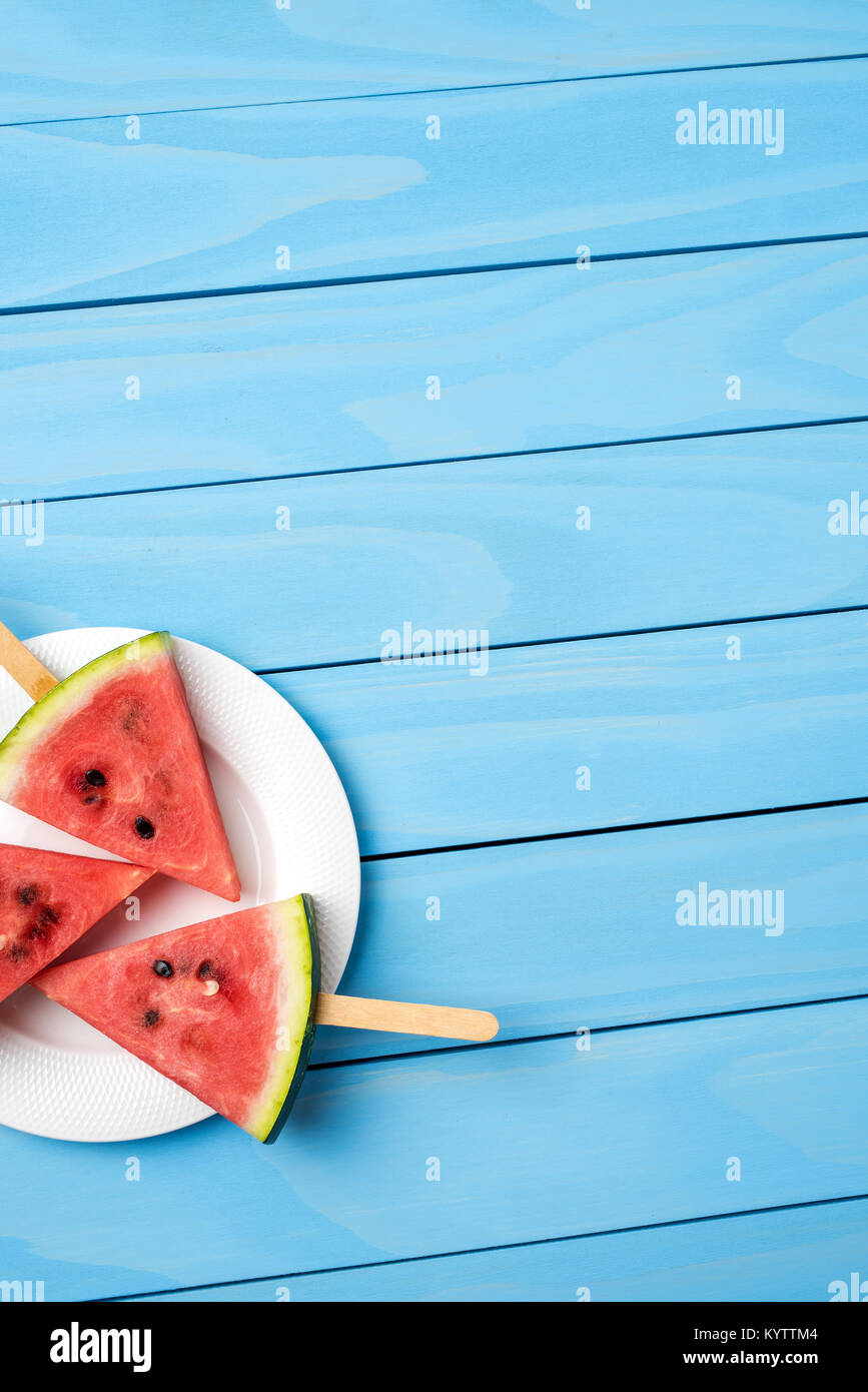 Watermelon slices on blue wooden table. Food background Stock Photo - Alamy