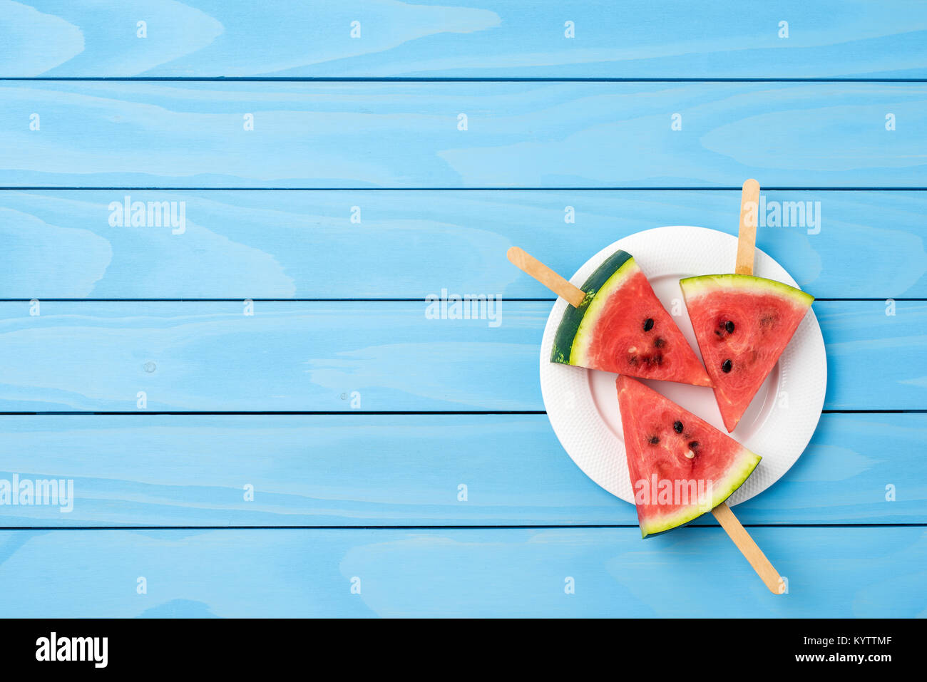 Watermelon slices on blue wooden table. Food background Stock Photo - Alamy