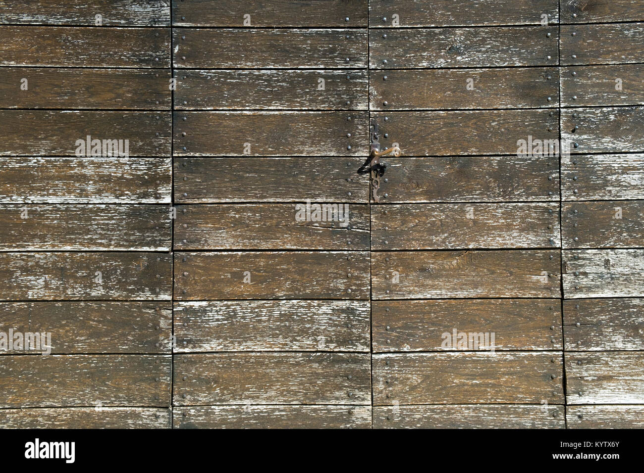 Full frame pattern of the planks of an unsual wooden door construction. Timber deteriorating due to breakdown of treatment coating. Stock Photo
