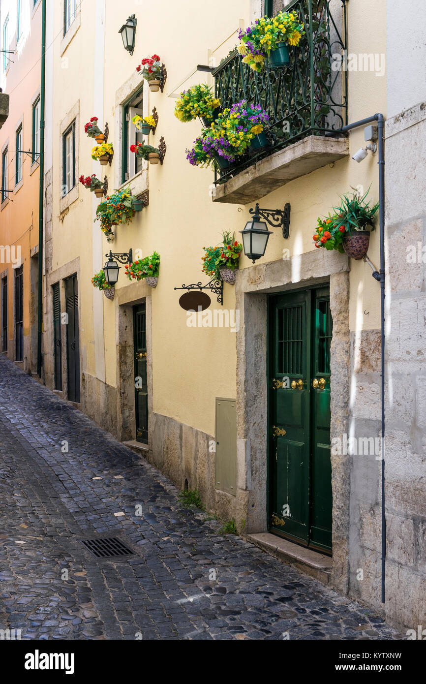 Narrow street and the facade of a building with flowers in the ...