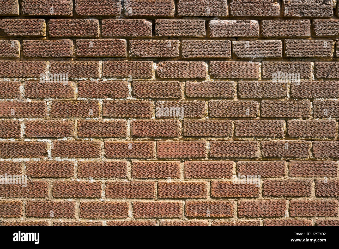 An old weathered, damaged, brick wall needs repairs. full frame