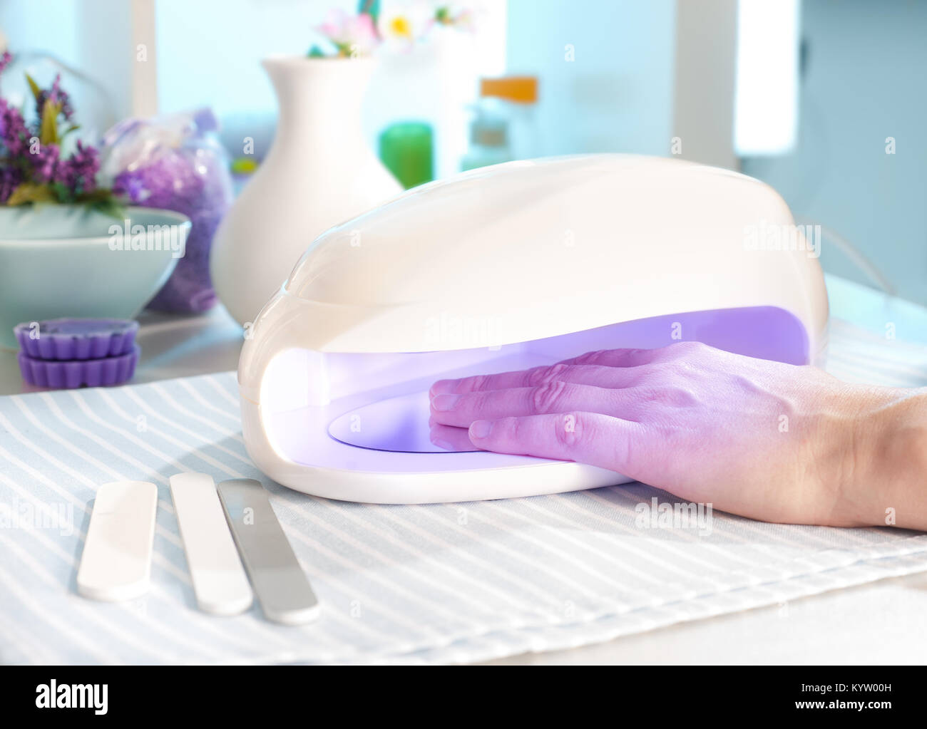 Nail salon, a female hand inside drying UV light machine Stock Photo