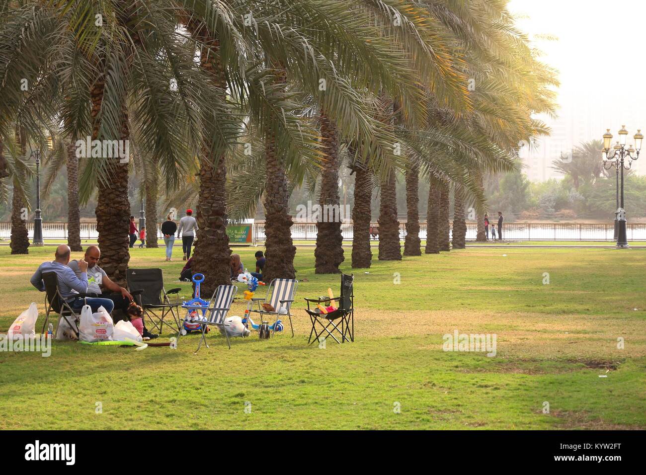 SHARJAH, UAE - DECEMBER 10, 2017: People visit Al Nakheel Oasis park with palm trees in Sharjah, UAE. This third populous city of UAE is the capital o Stock Photo