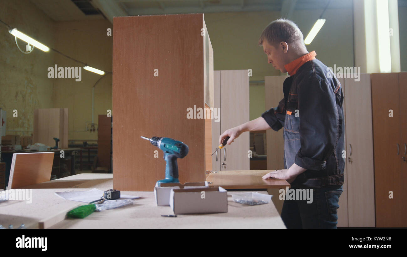 Carpenter working with an electric industrial stapler on the factory