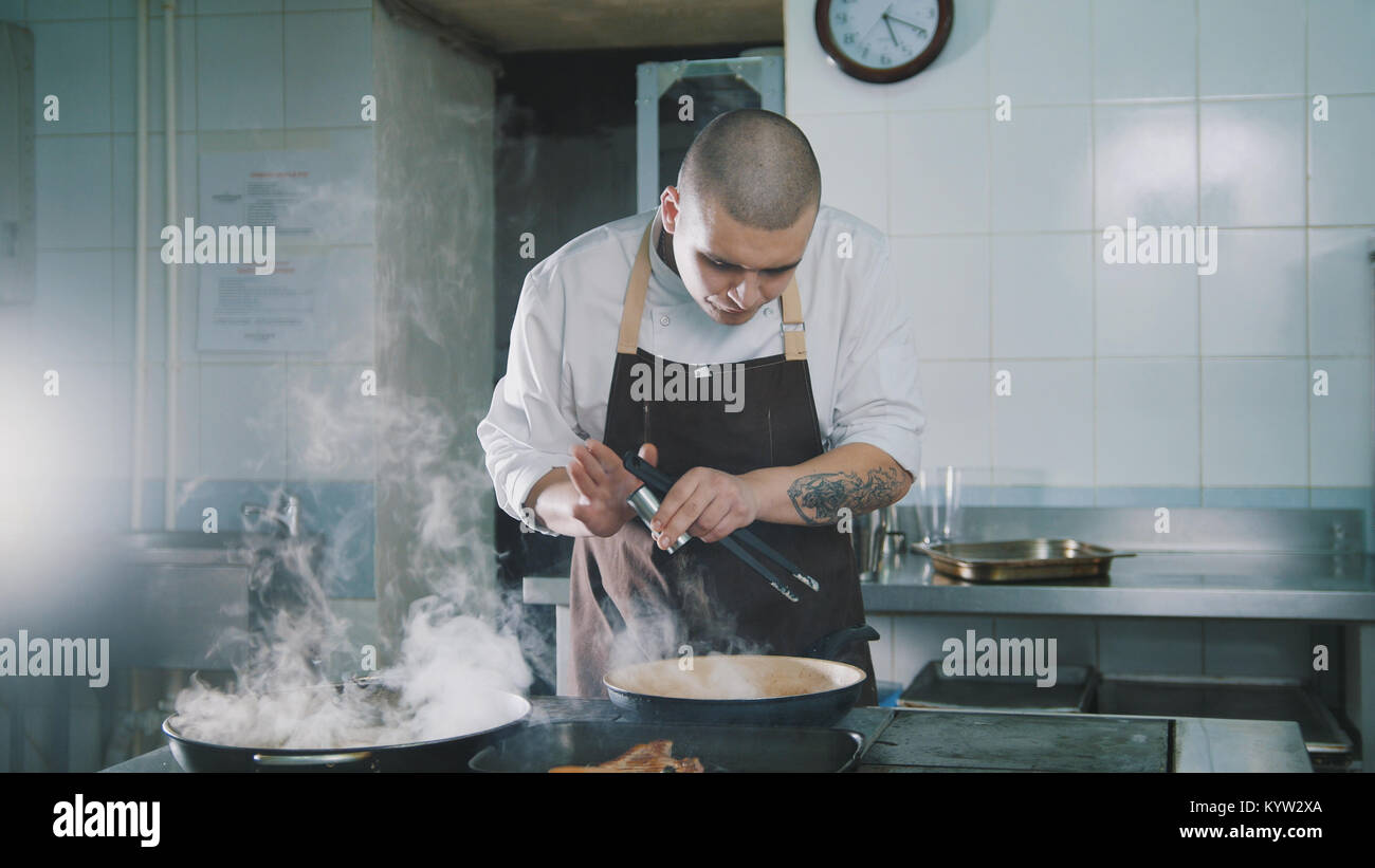 The cook adds spices to food Stock Photo - Alamy