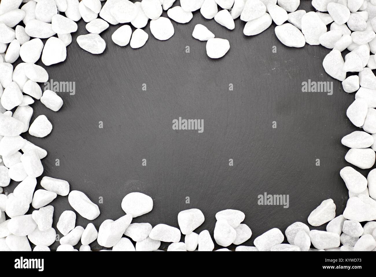 Background of dark slate edged with white pebbles Stock Photo