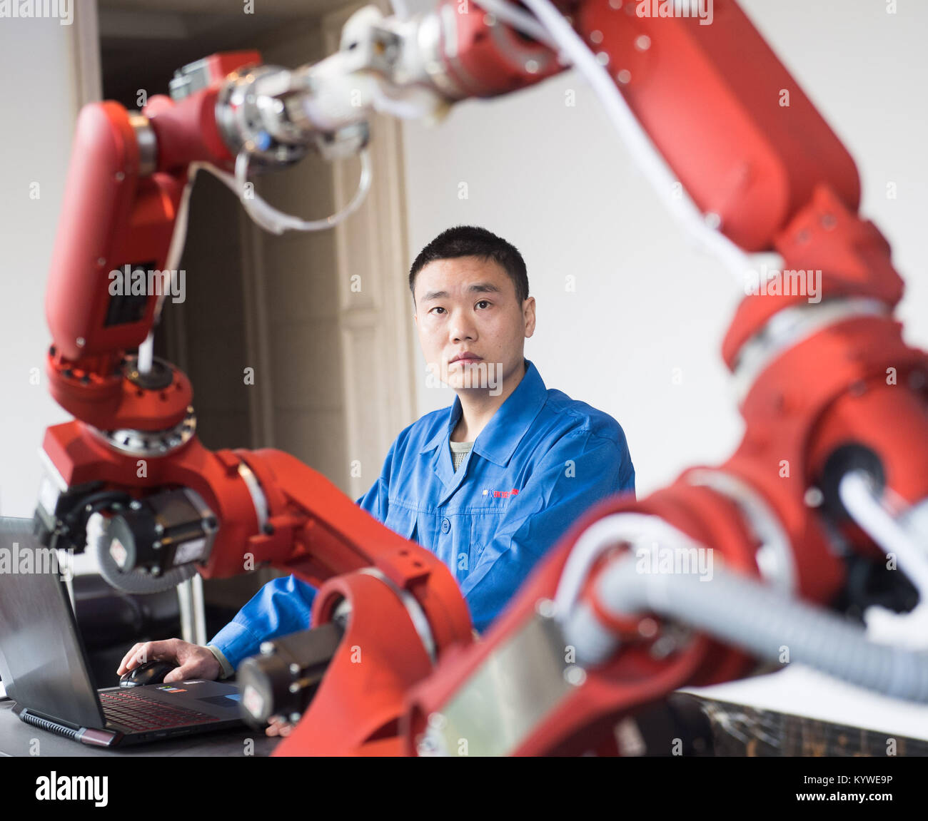 Rui'an, China's Zhejiang Province. 16th Jan, 2018. A technician from Rui'an Hsoar Group debugs a robot in Rui'an City, east China's Zhejiang Province, Jan. 16, 2018. Over 30 enterprises in Rui'an City purchased more than 500 robots to boost productivity. Credit: Weng Xinyang/Xinhua/Alamy Live News Stock Photo