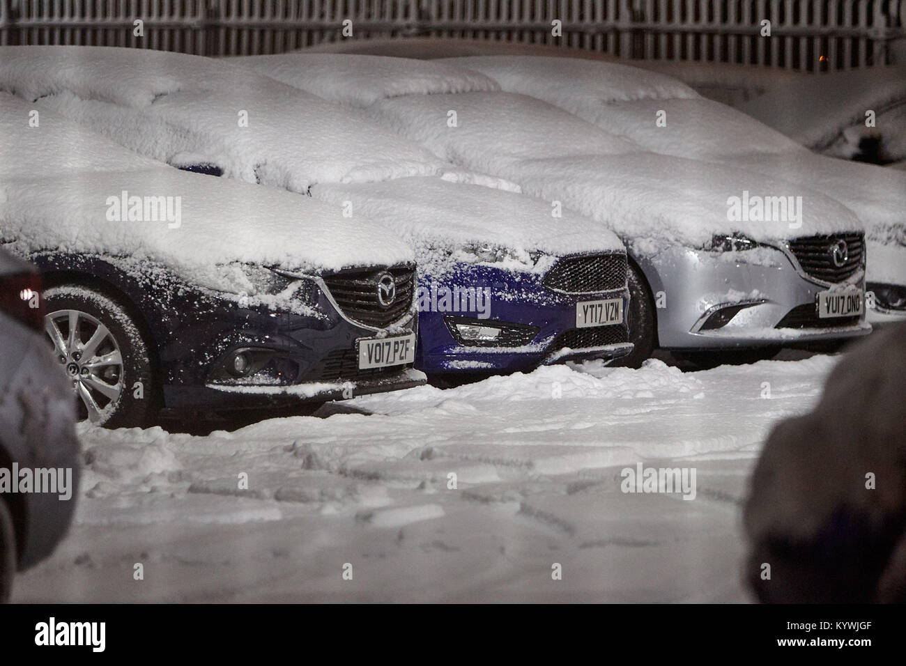 Newtownabbey, Northern, Ireland. 16th Jan, 2018. cars on a garage forecourt snowed in during amber weather warning as heavy snowfall starts to cover Newtownabbey outside Belfast, Northern Ireland, 16th January 2018 Credit: Radharc Images/Alamy Live News Stock Photo
