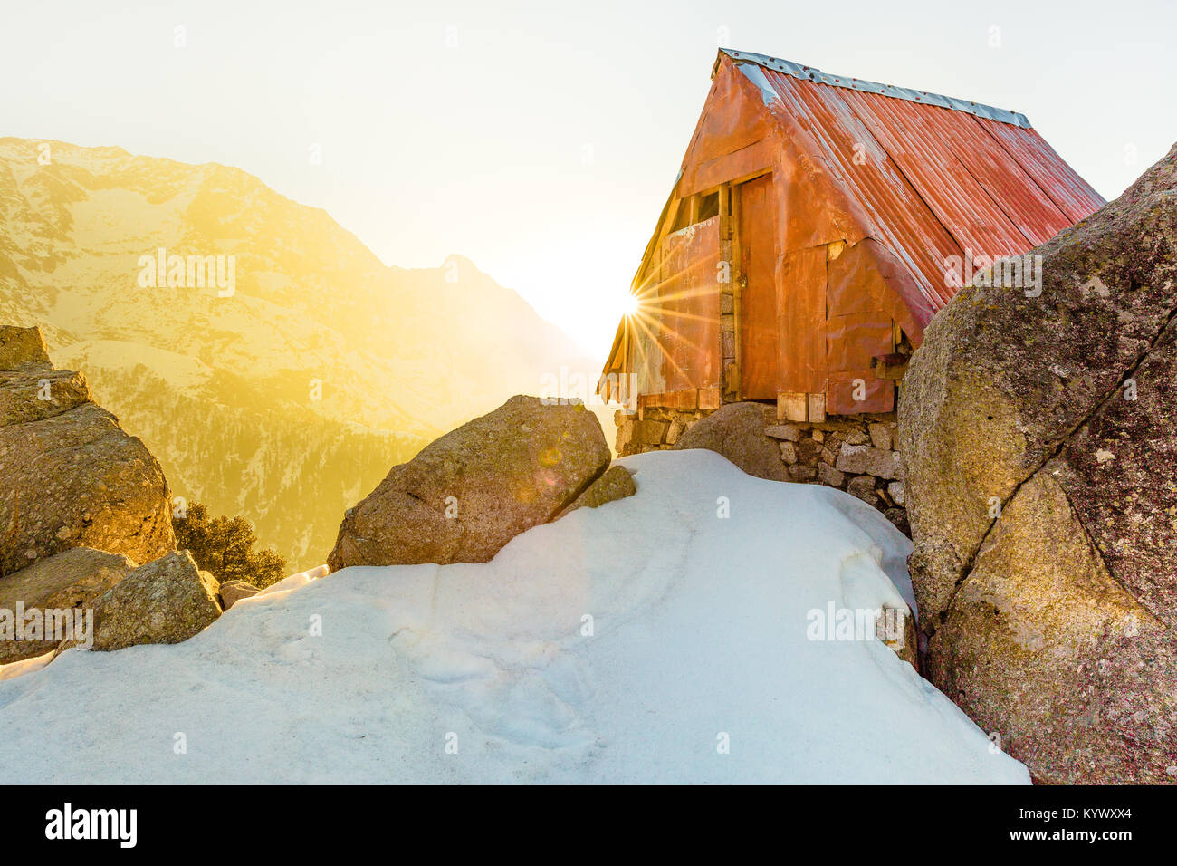 Secluded & beautiful Cabin in the snow mountains at Triund hill top, Mcleod ganj, Dharamsala, India during amazing sunrise from behind the mountains Stock Photo