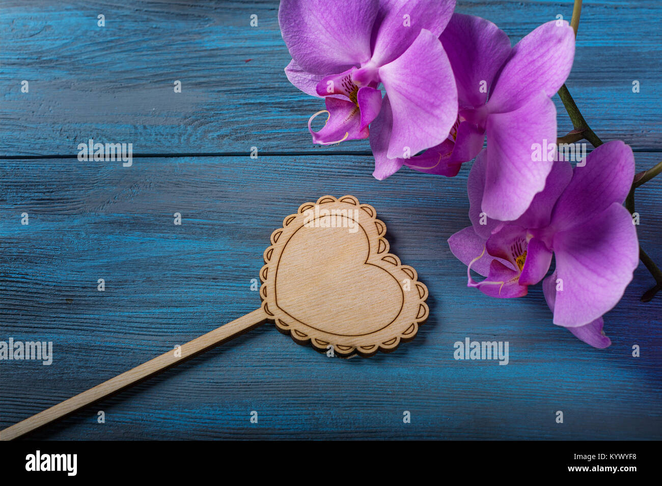 Purple Orchid and  heart  on blue, old wooden background Stock Photo