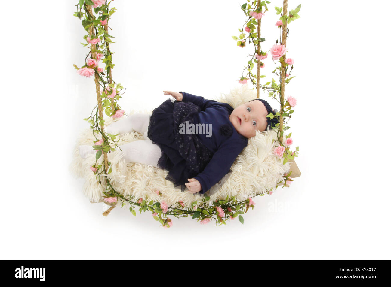 5 month old baby girl with in black dress laying on a swing Stock Photo