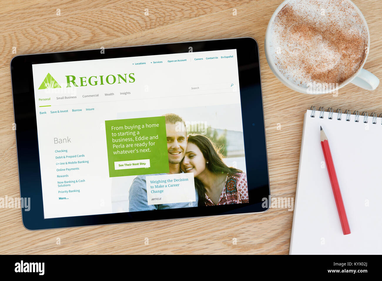 The Regions Financial Corporation website on an iPad tablet, on a wooden table beside a notepad, pencil and cup of coffee (Editorial only) Stock Photo