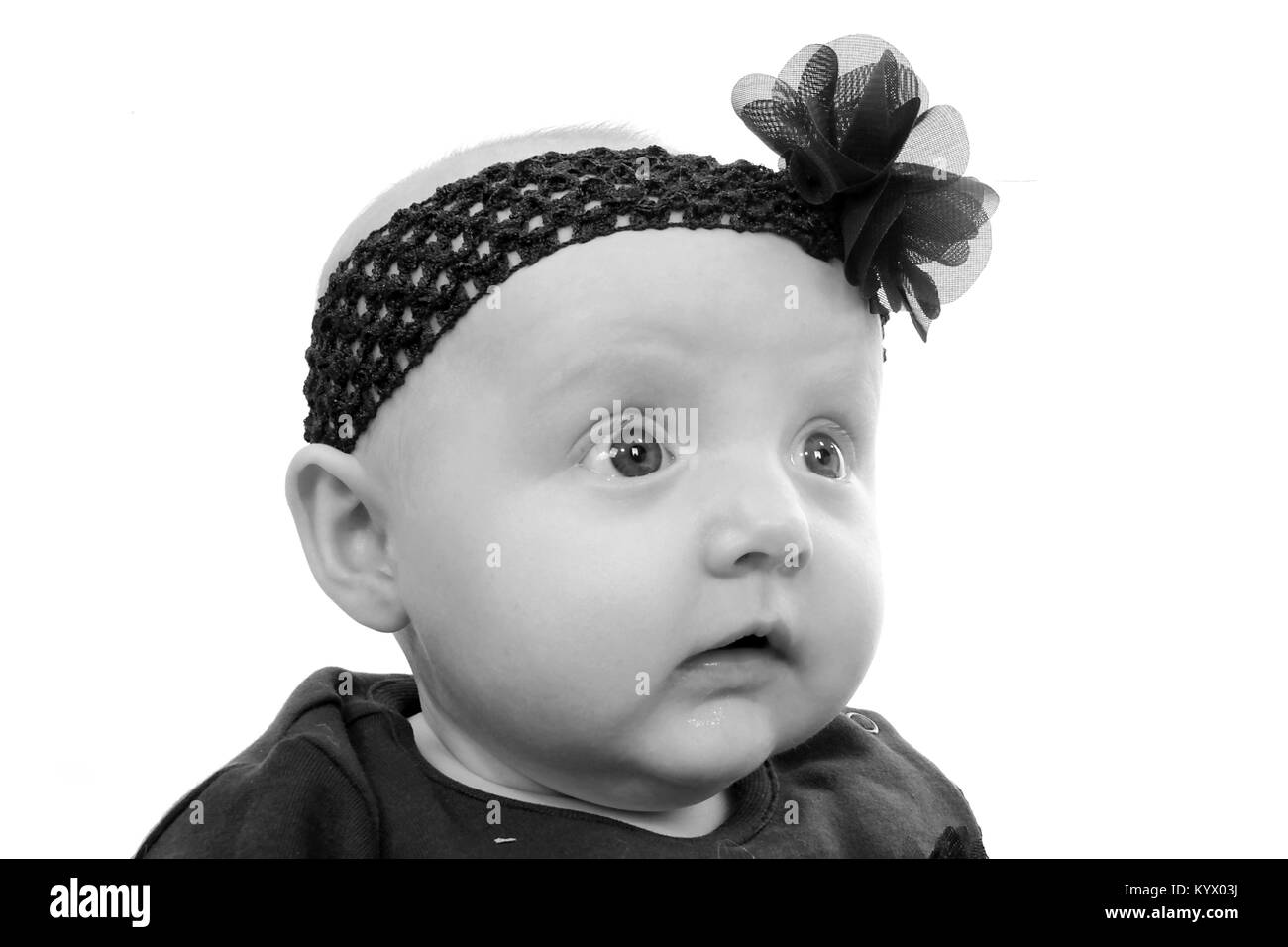 5 month old baby girl with in black dress sitting up Stock Photo