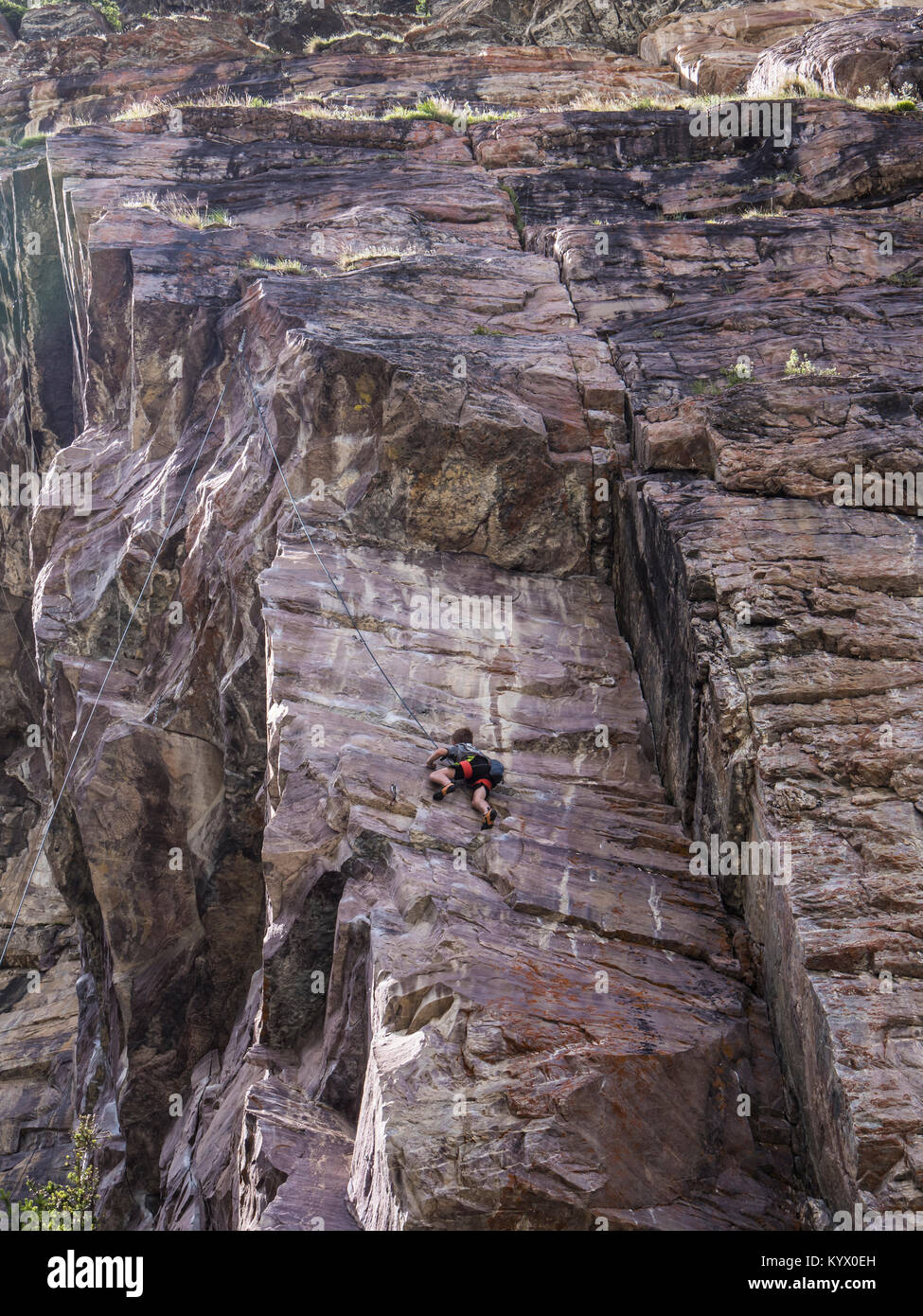 Rock climber on cliffs near the far end of Lake Louise, Banff National Park, Alberta, Canada. Stock Photo