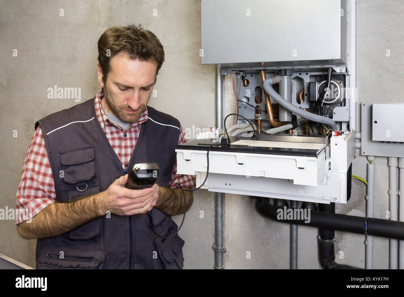 plumber repairing a condensing boiler Stock Photo