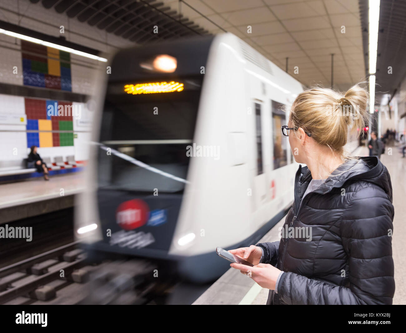 Wmata Using Phone Woman with a cell phone waiting for metro Stock Photo - Alamy