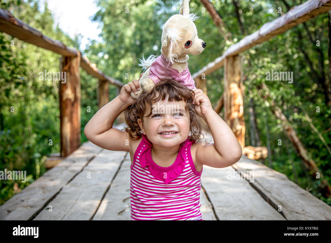 Beautiful little girl playing with a toy dog Stock Photo - Alamy