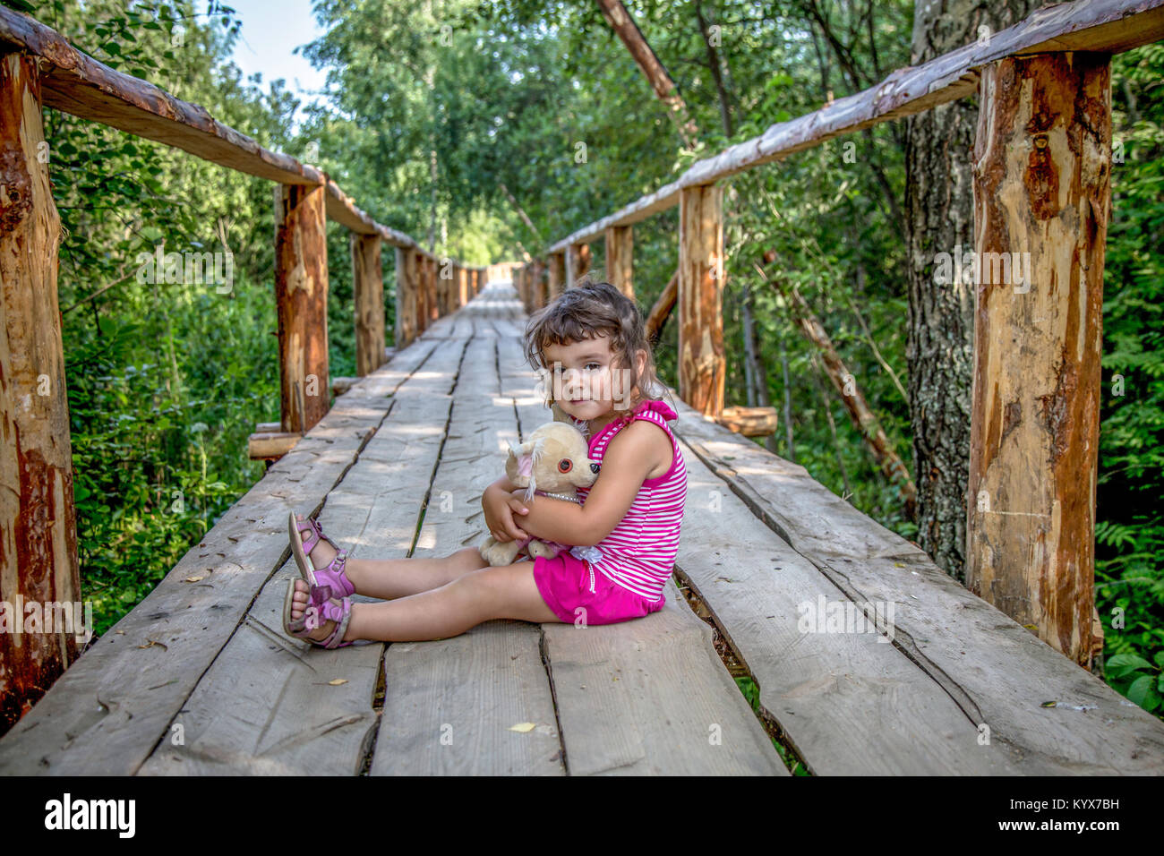 Beautiful little girl playing with a toy dog Stock Photo - Alamy