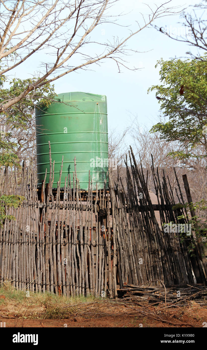 Green water tank in wooden stick fence at Victoria Falls Private Game Reserve, Zimbabwe. Stock Photo