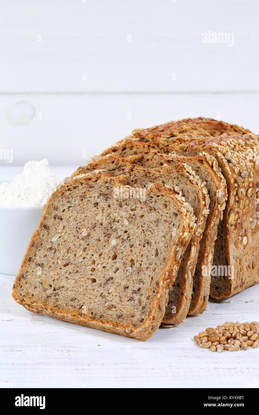 Whole wheat grain bread slice slices sliced loaf portrait format on wooden board wood Stock Photo