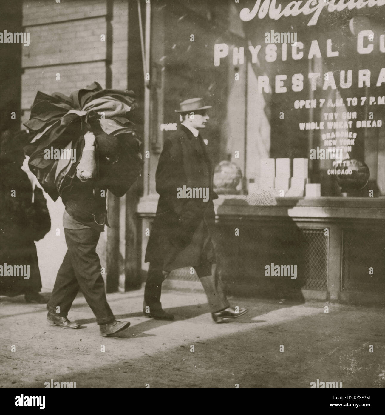 Man carrying bundle of garments. Bleeker St., N.Y. Stock Photo