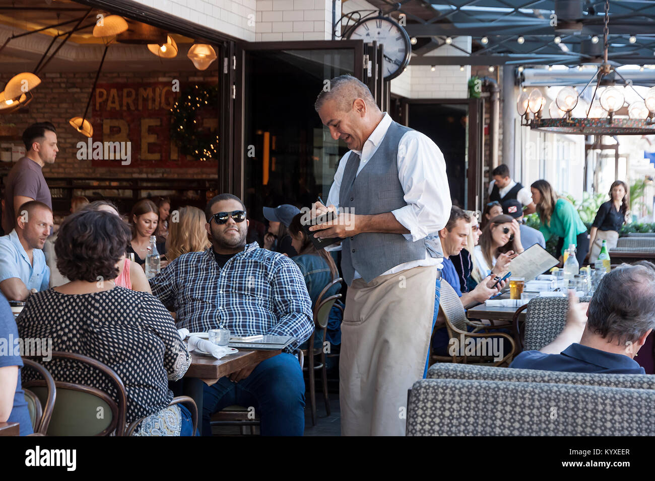 Waiter taking customer order on a notepad in a restaurant. Stock Photo