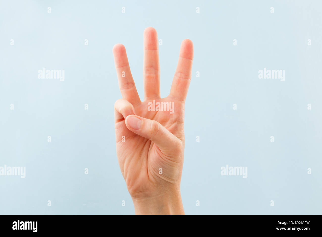 American sign language. Female hand showing letter W isolated on blue