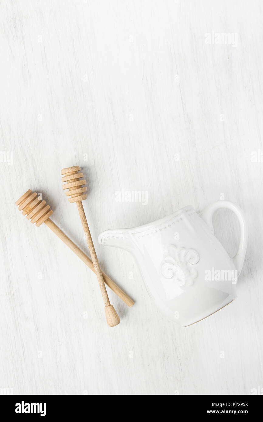 Vintage Ceramic Cream Milk Jug Wooden Honey Dippers Spoons on White Table. Holiday Baking Cooking Workshop Poster Concept. Christmas Easter. Kitchen I Stock Photo