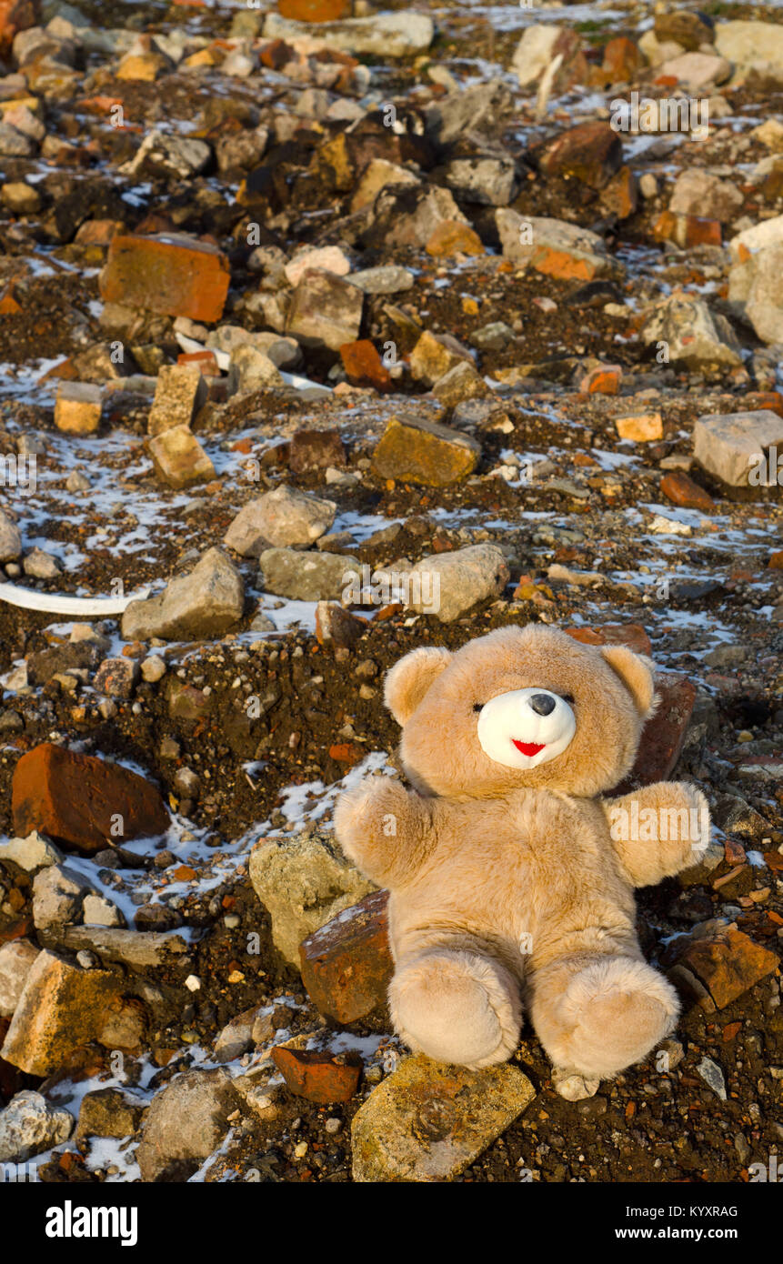 Sad picture: a child's teddy bear left on a heap of debris Stock Photo