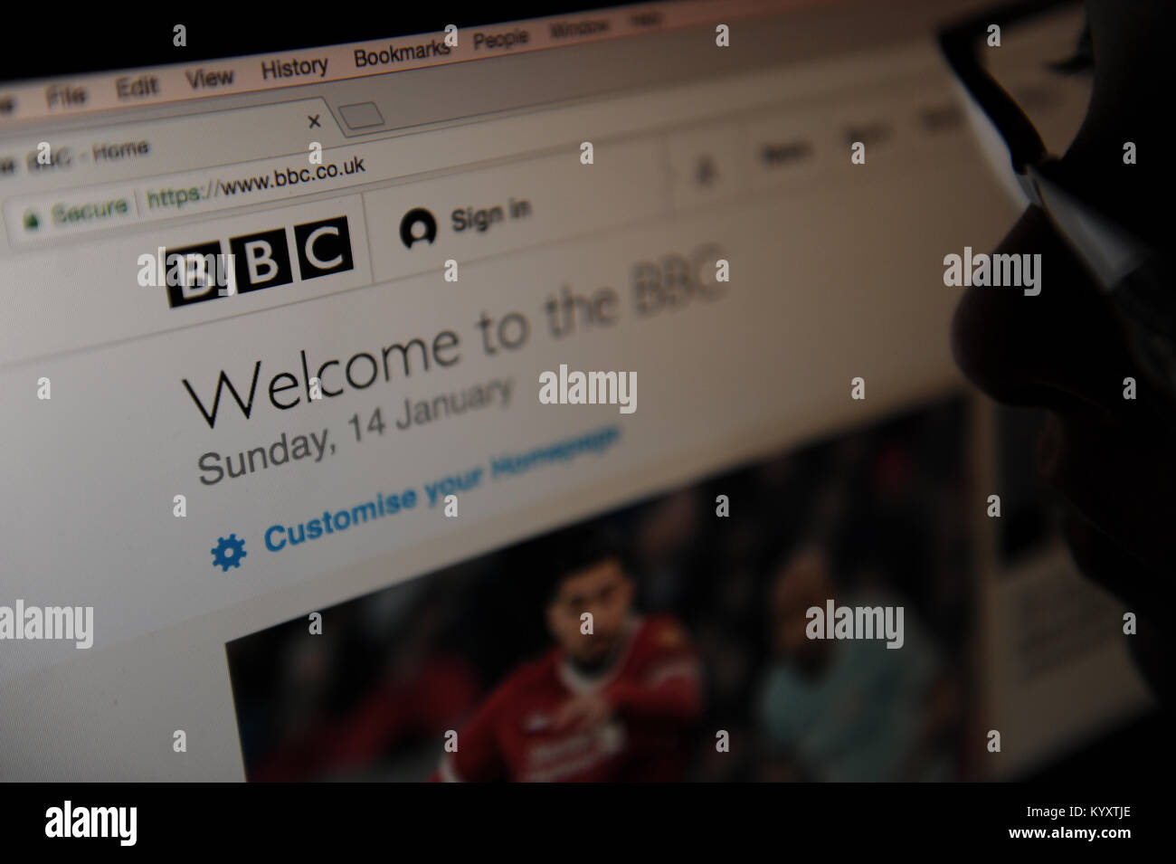 A woman looks at the BBC news homepage Stock Photo