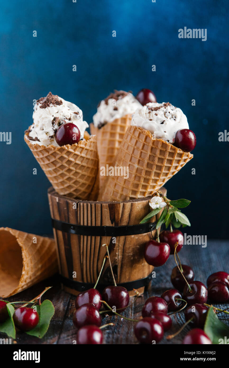 Close-up of ice cream with cherries on table against colored background Stock Photo