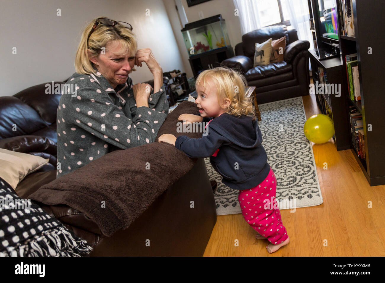 2 year old girl concerned because grandmother is crying Stock Photo