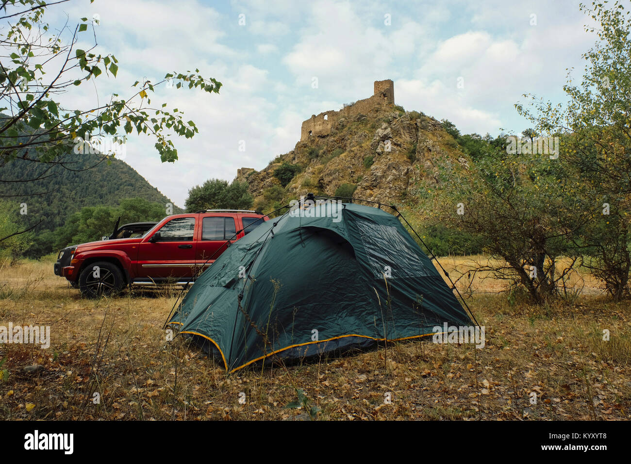 Tent by Sports Utility Vehicle against mountains at campsite Stock Photo