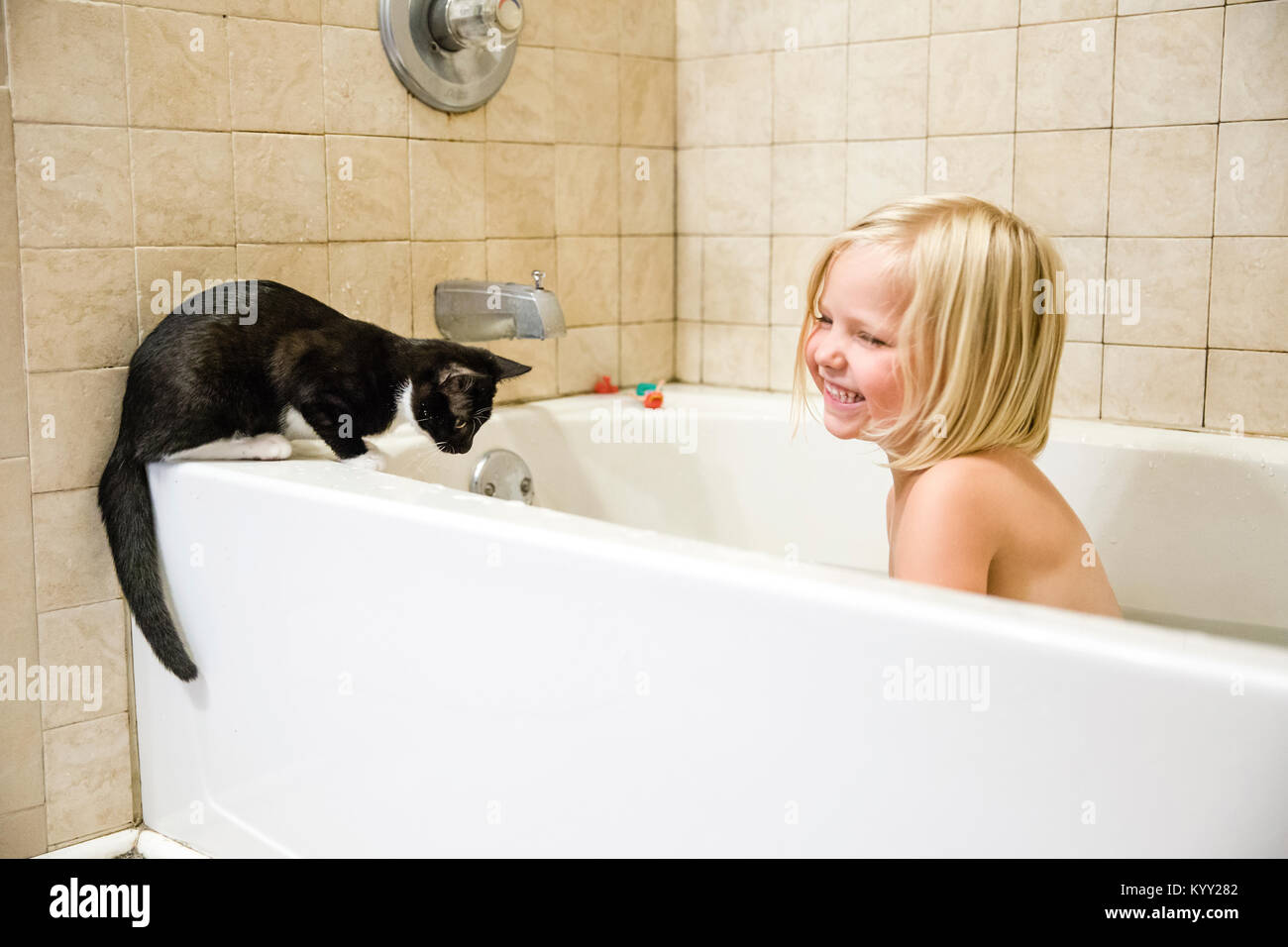 Cheerful girl with cat in bathtub Stock Photo - Alamy