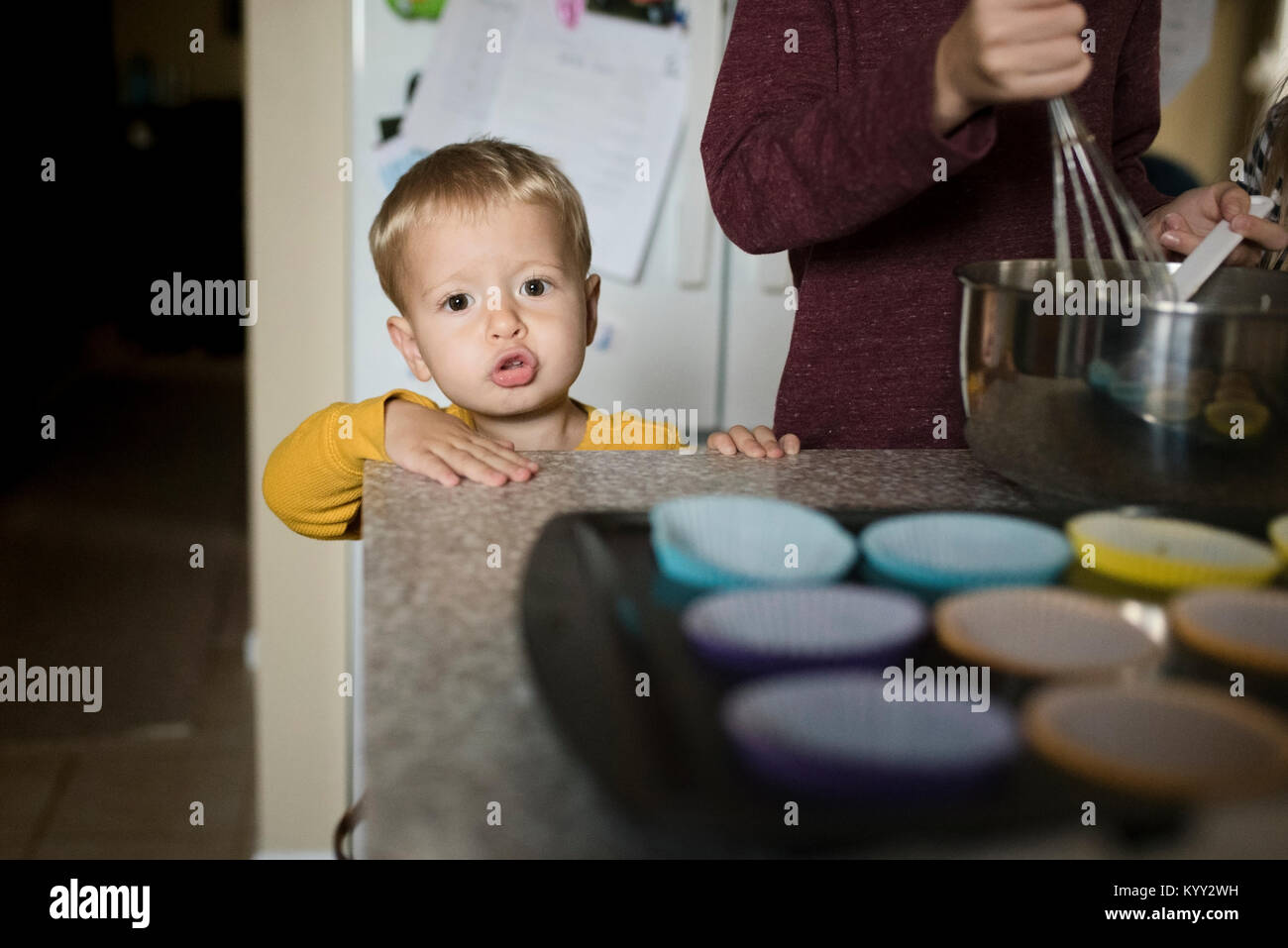 Portrait of cute boy standing by brother preparing food in kitchen Stock Photo